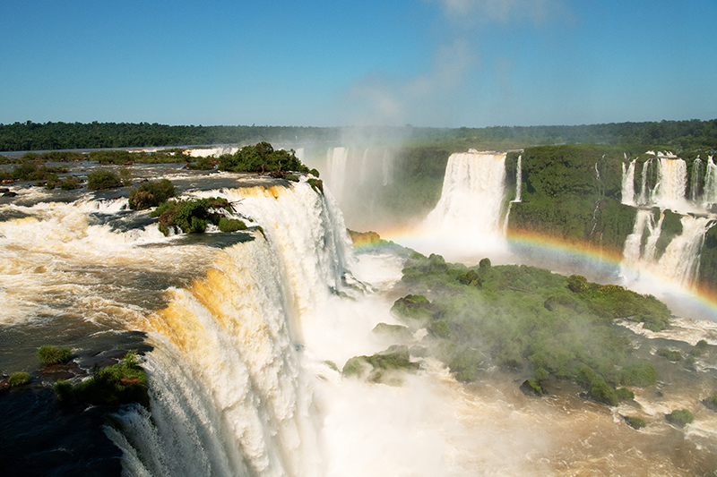 Photographed the amazing natural beauty of Iguazu Waterfall from the aerial vantage point. Breathtaking view of the Iguassu Falls, the Iguassu National Park at the borders of Argentina, Brazil and Paraguay. Extraordinary look out for a rainbow as the sun lights the tumbling waters.